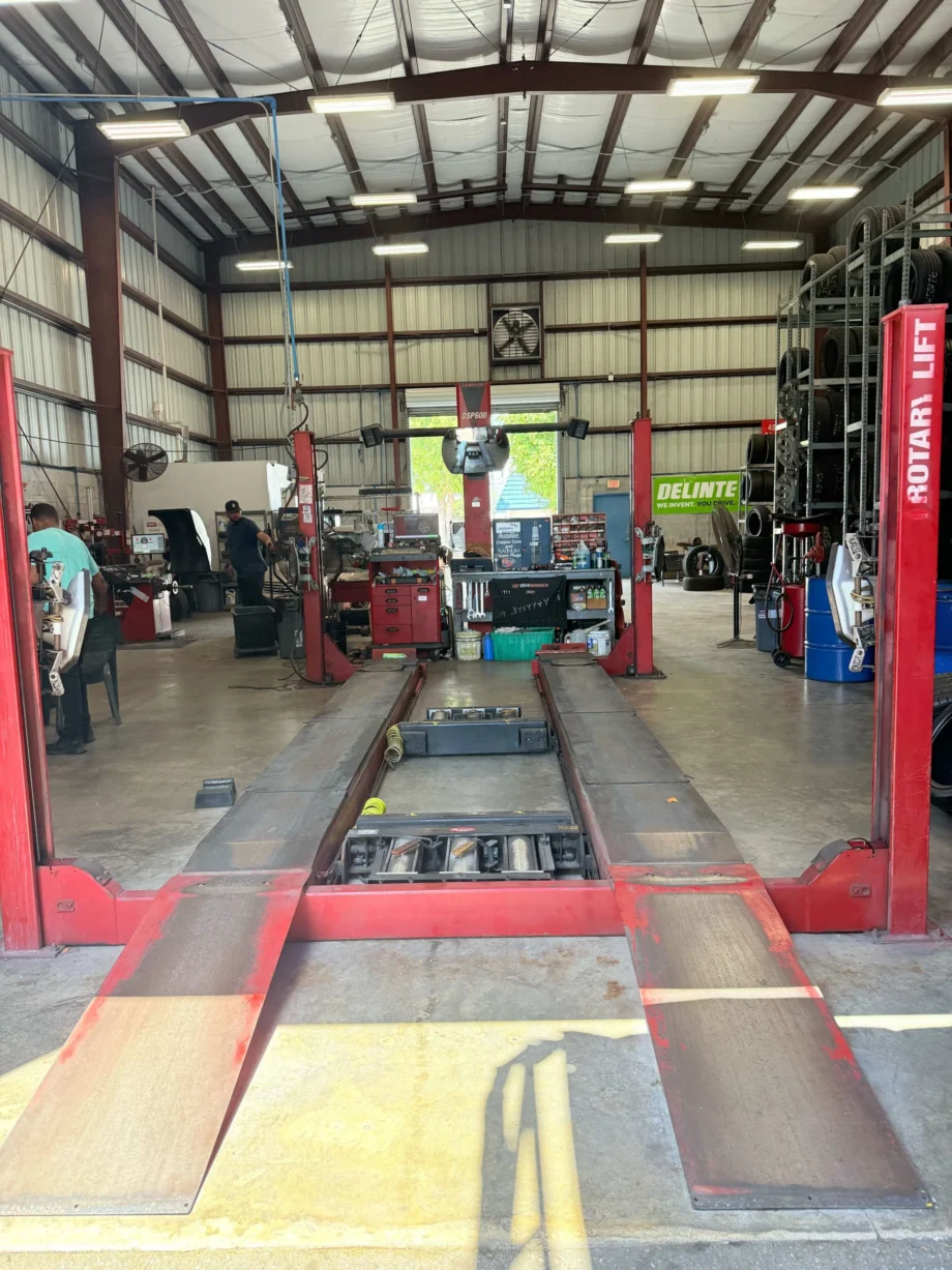 Empty red car lift inside auto repair shop